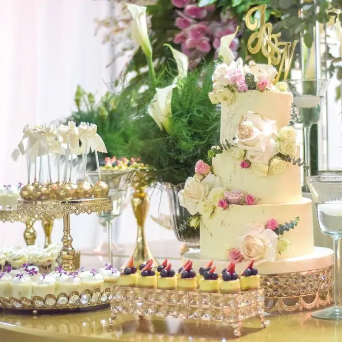 Torta de varios pisos con flores y mesa de postres
